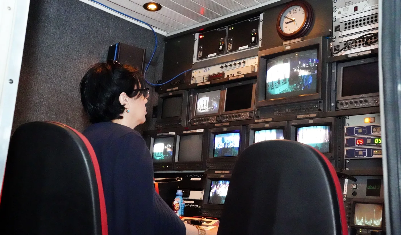 Technicienne dans une salle de contrôle audiovisuelle équipée de plusieurs écrans